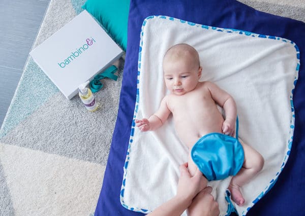 Picture of a baby having a massage lying on a massage mat and wearing a bumbino (for nappy-free time)