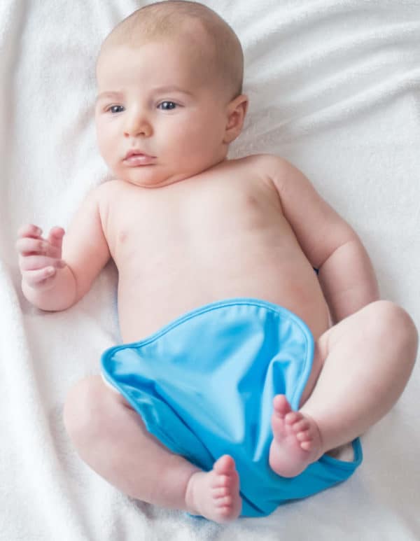 Baby wearing a blue bumbino , enjoying nappy-free time