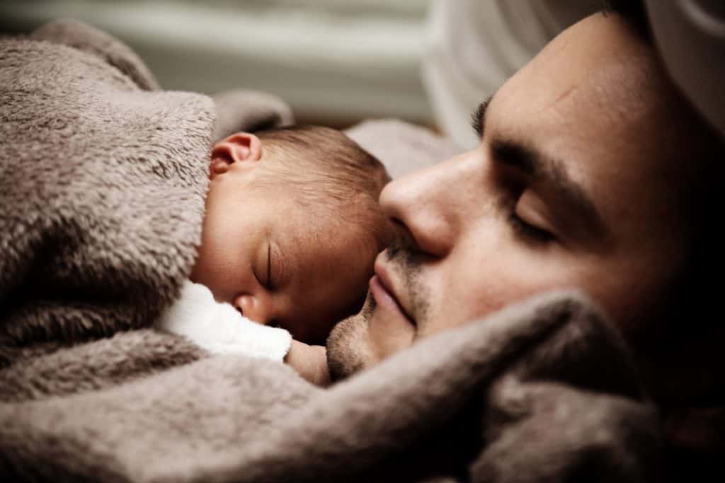 Dad cuddling newborn baby